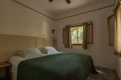 a bedroom with a green bed with a window at Star Mountain Jungle Lodge - Only 4x4 Vehicles, No Meals in Mal País