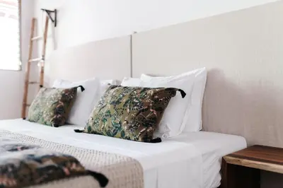 a bed with white sheets and pillows on it at Star Mountain Jungle Lodge - Only 4x4 Vehicles, No Meals in Mal País