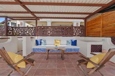 a patio with a table and two chairs at Sunshine Escape with a Rooftop Patio in Coco