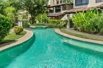 a swimming pool in the middle of a house with blue water at Sunshine Escape with a Rooftop Patio in Coco