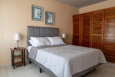a bedroom with a bed and a wooden cabinet at Villa Paz in San José