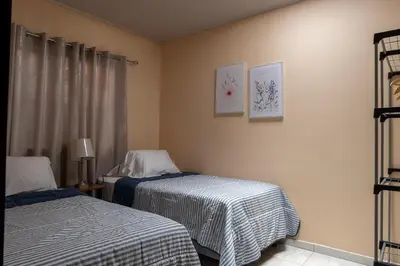 a hotel room with two beds and a window at Villa Paz in San José