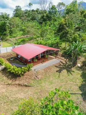 a building with a red roof on a hill at Cabaña Timarama in Fortuna