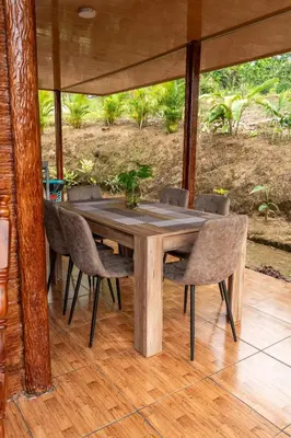 a wooden table and chairs on a porch at Cabaña Timarama in Fortuna