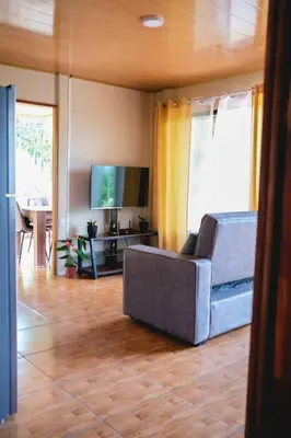 a living room with a couch and a television at Cabaña Timarama in Fortuna
