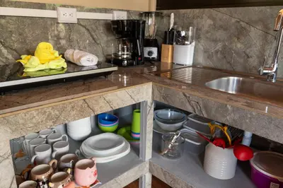 a kitchen counter with a sink and some dishes at Cabaña Timarama in Fortuna