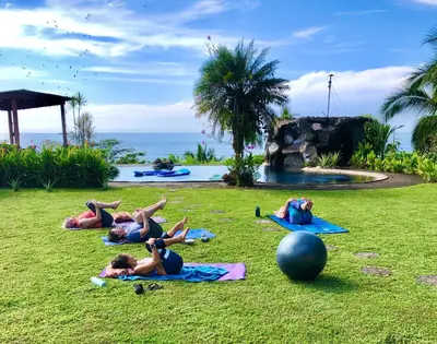 a group of people doing yoga in the grass at Casa Vista Pacifico in Esterillos