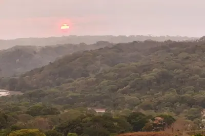 a sun setting on a hill with trees at Hermosa cabaña con espacios al Aire Libre! in San Francisco