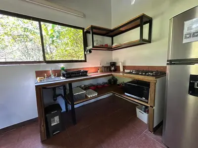 a small kitchen with a counter and a refrigerator at Hermosa cabaña con espacios al Aire Libre! in San Francisco