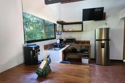 a kitchen with a table and a sink and a refrigerator at Hermosa cabaña con espacios al Aire Libre! in San Francisco