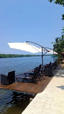 a group of chairs sitting on a dock in the water at Valverde Glamping & Ecolodge in Tortuguero