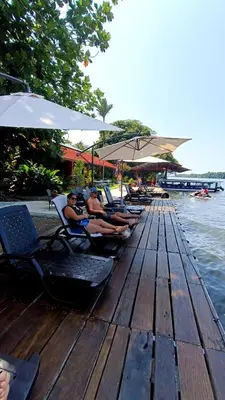 a group of people sitting on a dock near the water at Valverde Glamping & Ecolodge in Tortuguero