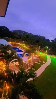 a resort with a swimming pool at night at La Piedra in Alajuela City