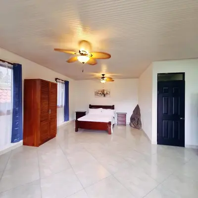 a bedroom with a bed and a ceiling fan at La Piedra in Alajuela City