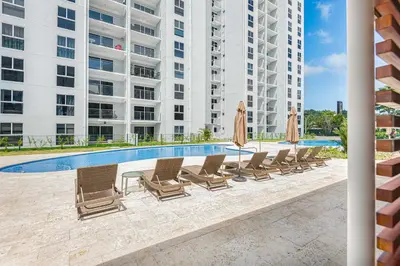 a group of chairs and umbrellas next to a pool at Upstay - 3BR New Condo in Jaco 5mins to Beach in Jacó