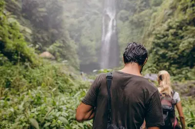 a group of people walking down a trail towards a waterfall at Upstay - 3BR New Condo in Jaco 5mins to Beach in Jacó