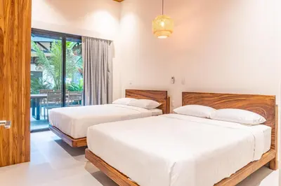 a bedroom with two beds and a balcony at Coco Nosara Villas Guiones Family Resort Casa José in Nicoya
