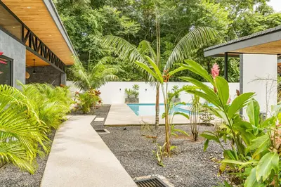 a garden with a swimming pool and some plants at Coco Nosara Villas Guiones Family Resort Casa José in Nicoya
