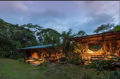 a wooden building with tables and chairs in a yard at Finca Anjala - Architectural lodge on sustainable in Ojochal