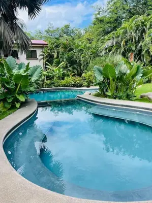 a swimming pool with blue water in a garden at Casa de Romá in Coco