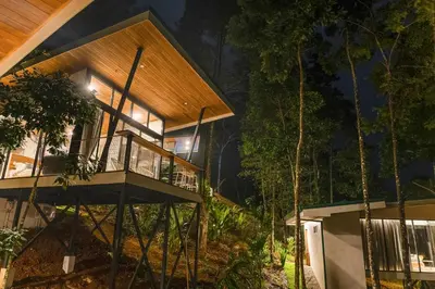 a house in the woods at night at Pandanus Lodge & Retreats Bungalow Heliconia in Cariblanco