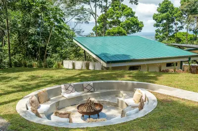 a fire pit in the middle of a yard at Pandanus Lodge & Retreats Bungalow Heliconia in Cariblanco