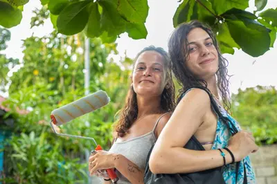 two women standing next to each other with a hair dryer at Argdivan Beach Hostel in Sámara