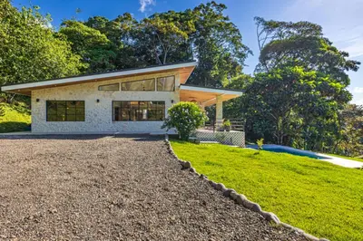 a house with a gravel driveway in front of it at House 15 min from the beach with river access in Ojochal