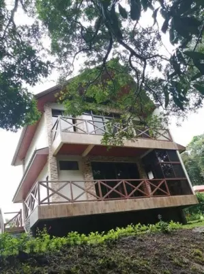 a house with a balcony on the side of it at Cabañas Refugio Verde Monteverde in Monteverde Costa Rica