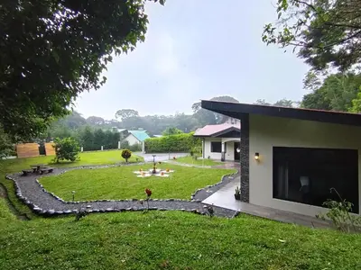 a backyard with a house and a lawn at Cabañas Refugio Verde Monteverde in Monteverde Costa Rica