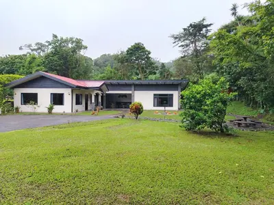 a house with a grass yard in front of it at Cabañas Refugio Verde Monteverde in Monteverde Costa Rica