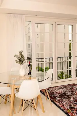 a dining room with a glass table and white chairs at Comfort and style in San José