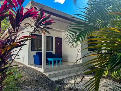 a villa with a blue bench in the front yard at Koba Village Santa Teresa in Santa Teresa Beach