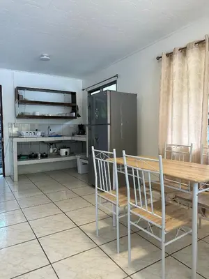a dining room with a table and a refrigerator at Koba Village Santa Teresa in Santa Teresa Beach