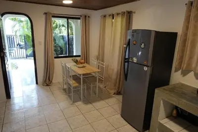 a kitchen with a refrigerator and a table with chairs at Koba Village Santa Teresa in Santa Teresa Beach