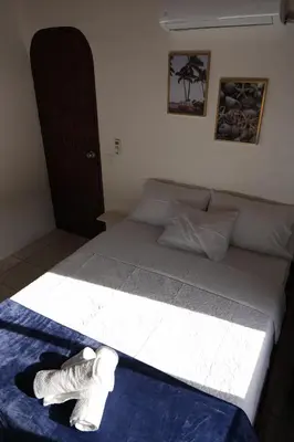 a bed with two pairs of socks on top of it at Koba Village Santa Teresa in Santa Teresa Beach