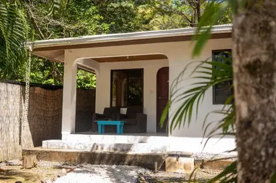 a small house with a porch with a blue table at Koba Village Santa Teresa in Santa Teresa Beach