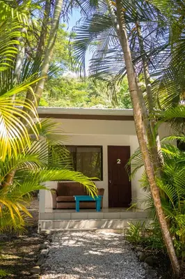 a house with a couch in the middle of trees at Koba Village Santa Teresa in Santa Teresa Beach
