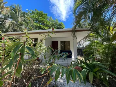 a small white house in the middle of a garden at Koba Village Santa Teresa in Santa Teresa Beach