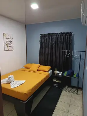 a bedroom with a bed with yellow sheets and a window at HOUSE Of Rainbow in Tortuguero