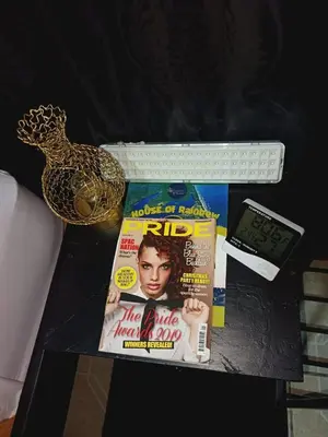 a table with a magazine and a clock and a phone at HOUSE Of Rainbow in Tortuguero
