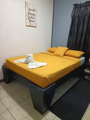 a bed in a room with yellow sheets and pillows at HOUSE Of Rainbow in Tortuguero