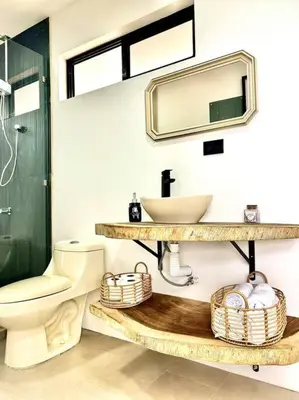 a bathroom with a sink and a toilet and a mirror at Cabaña con piscina y vista al mar in Puntarenas