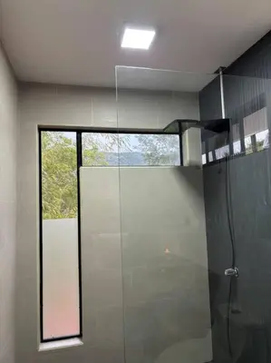 a bathroom with a shower with a window in it at Cabaña con piscina y vista al mar in Puntarenas