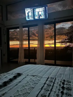 a bedroom with a window with a view of the sunset at Cabaña con piscina y vista al mar in Puntarenas