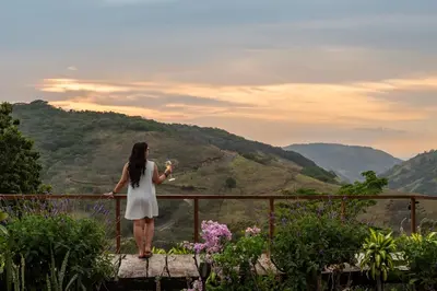 a woman standing on a ledge looking at a valley at Monteverde Alas Glamping in Monteverde Costa Rica