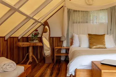 a bedroom with a bed and a mirror at Monteverde Alas Glamping in Monteverde Costa Rica