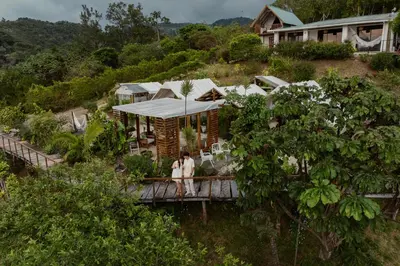 a house on a hill with two people standing on a bridge at Monteverde Alas Glamping in Monteverde Costa Rica