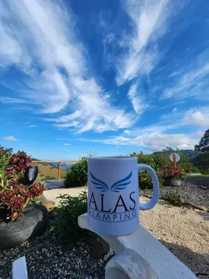 a white coffee cup with aas handwriting on it at Monteverde Alas Glamping in Monteverde Costa Rica