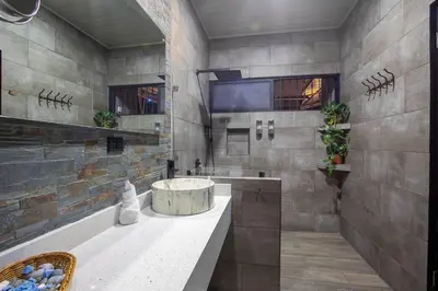 a large bathroom with a sink and a large wall at Villa Graceland - Arenal Volcano View in Fortuna